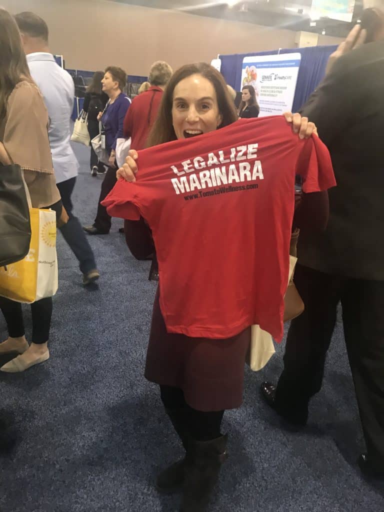 Allison Stowell holds up a t-shirt reading "Legalize Marinara"