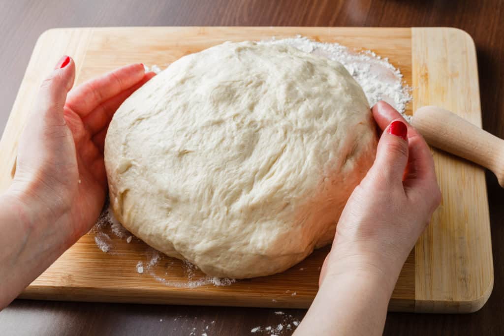 Preparing pizza dough in kitchen