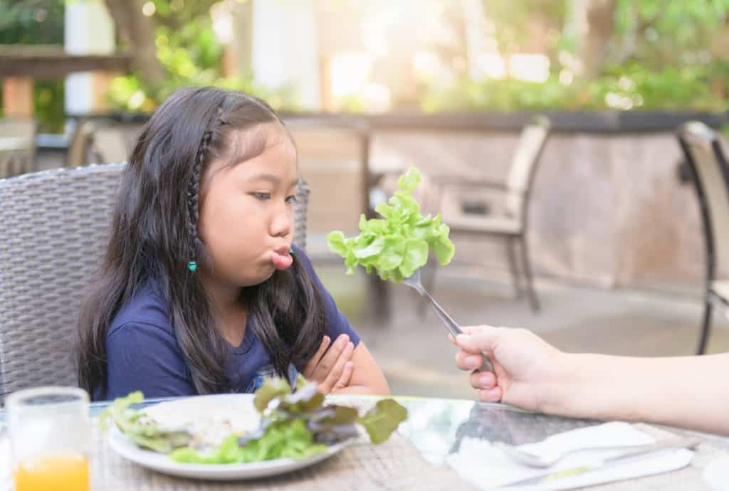 Girl pouting at lettuce