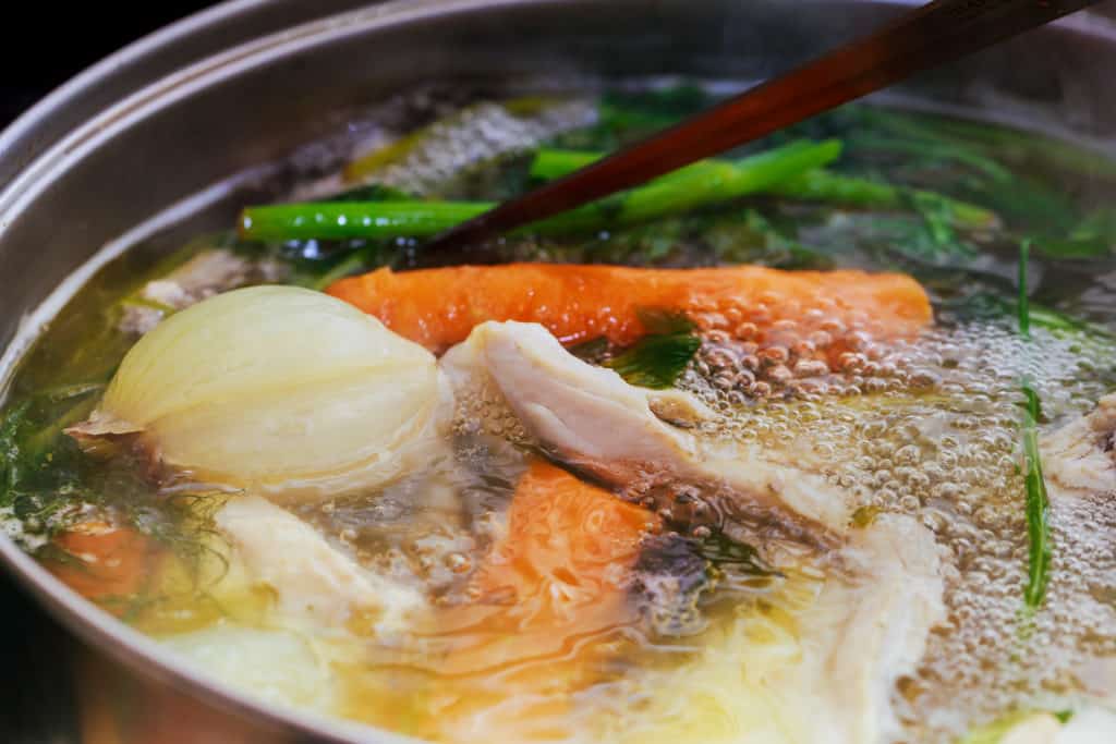 Chicken stock cooking in a pot