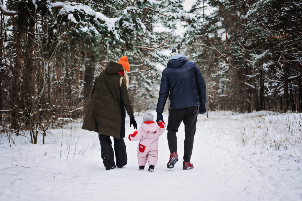 Two parents with a small child in a winter forest