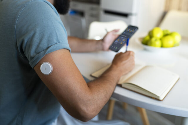 diabetic man checking-glucose patch sensor