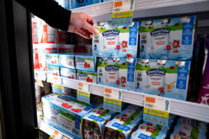hand grabbing yogurt on shelf
